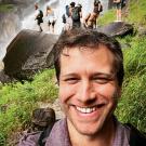 A photo of Evan Warfel in front of Lower Yosemite Falls